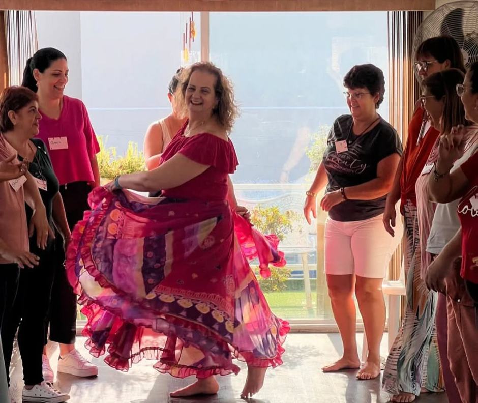 Fabi conduzindo uma roda de mulheres em um encontro presencial